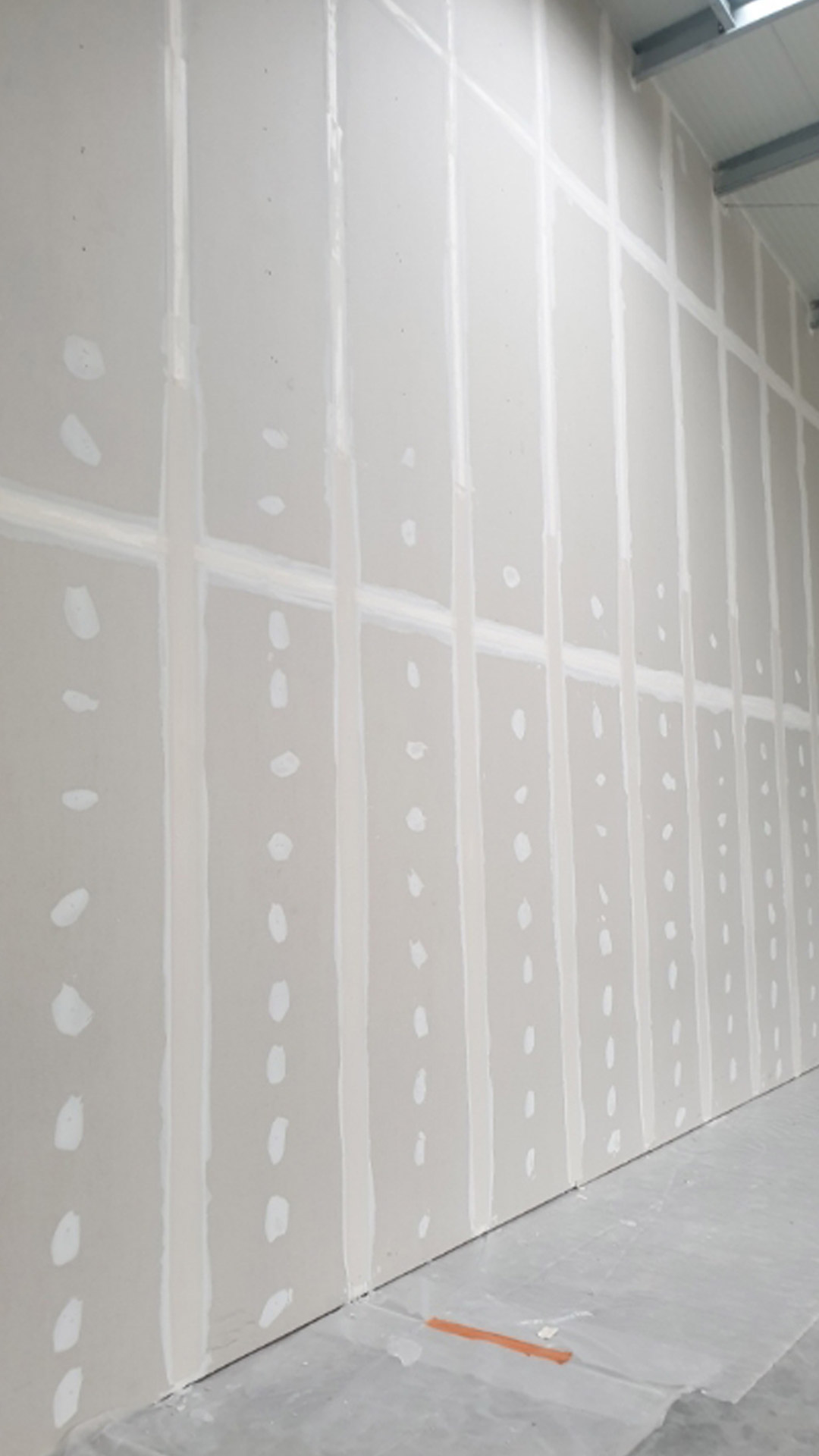 Pose de panneaux isolants préparant l'installation de plaques de placo pour une isolation thermique et phonique optimale.