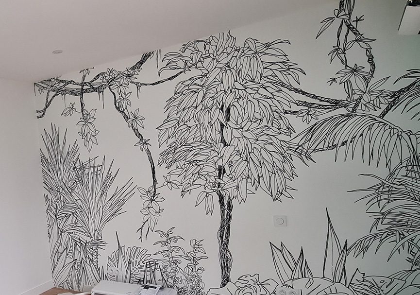 Fresque murale en noir et blanc représentant une forêt tropicale avec des plantes exotiques et des lianes, dans une pièce au sol en parquet clair.